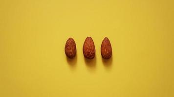 The three almonds on yellow background photo