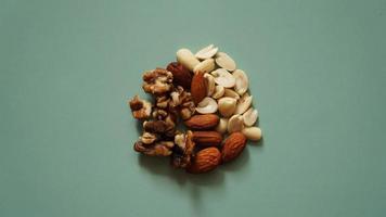 A handful of nuts on bright green background, color background photo