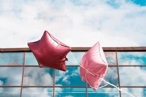 Pink balloons like star in blue sky photo