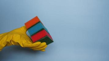 Hand in glove holding few washing sponges photo