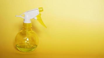 Spray bottle on yellow background photo