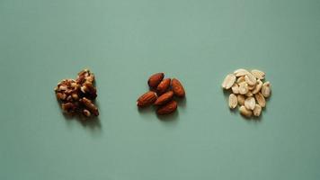 A handfuls of nuts on bright green background, color background photo