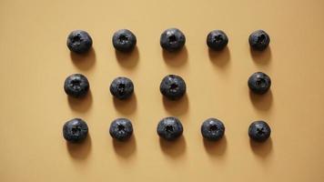 Blueberries are laid out in rows on a gold background photo