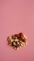 A handful of nuts on bright pink background, color background photo