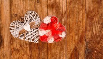 Rosas rojas y blancas y corazón blanco del día de San Valentín sobre fondo de madera foto
