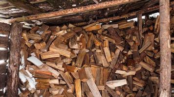 Logging in the village. Chopped logs under a canopy in winter photo