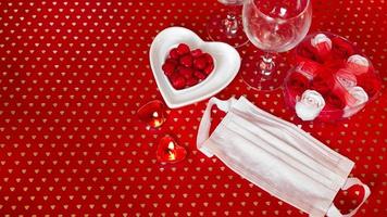 tabla de concepto del día de San Valentín. cena romantica con mascarilla medica foto