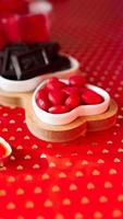 Chocolates and sweets on heart-shaped plates photo