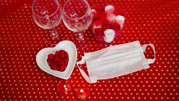 tabla de concepto del día de San Valentín. cena romantica con mascarilla medica foto