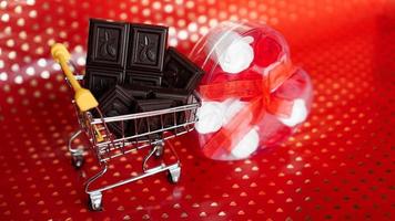 chocolate en carrito de la compra y rosas en rojo foto