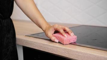 Female hand washing electric hob in the kitchen photo