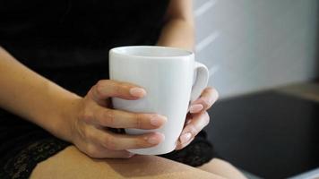 A closeup shot of the female holding a white cup in her hand photo