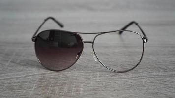 Broken sunglasses on grey wooden background photo