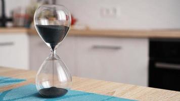 Closeup of hourglass with defocus kitchen on background photo