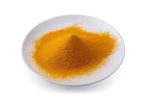 Dry Turmeric Organic Herbal or Turmeric Powder spice pile in a white bowl isolated on white background photo