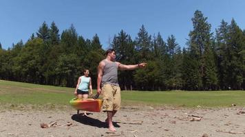 Paar trägt Kajak zum See video