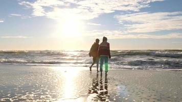 duas crianças correndo na praia video