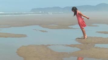 fille sautant dans la flaque d'eau à la plage, ralenti video