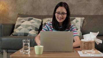 mujer asiática que usa la computadora portátil para el trabajo desde casa y el aprendizaje en línea. video