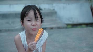 asiatisches süßes Mädchen mit langen schwarzen Haaren, Seifenblasen bläst. video