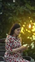 Beauty latin young woman in white floral dress reading on smartphone