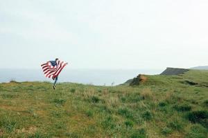 A little boy runs with the flag of the United States photo