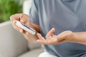 Woman checking blood sugar level by Digital Glucose meter. photo