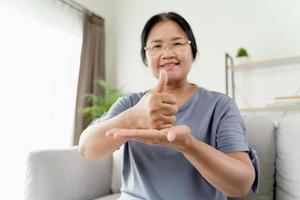 La mujer sorda discapacitada que usa el lenguaje de señas se comunica con otras personas. foto