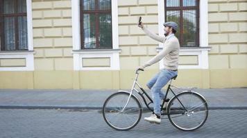 Varón joven elegante con bicicleta retro en las calles video