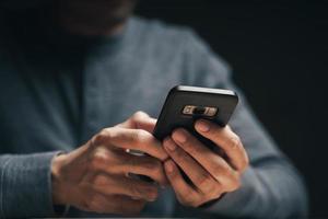 Man using a smartphone on the table, searching, browsing, social media photo