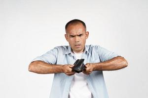 Man holding upside down and looking inside his empty wallet photo