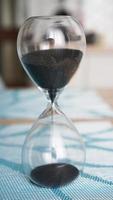 Closeup of hourglass with defocus kitchen on background photo