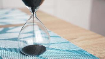 Closeup of hourglass with defocus kitchen on background photo