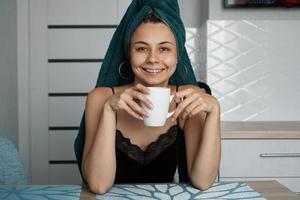 Beautiful girl sits in the kitchen with a cup of coffee. Relax photo