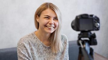 Cheerful female blogger recording video photo