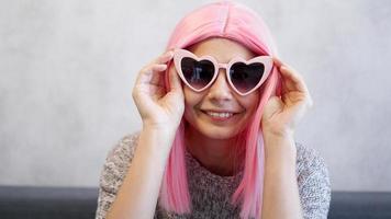 Woman wearing glasses and pink wig - positive portrait