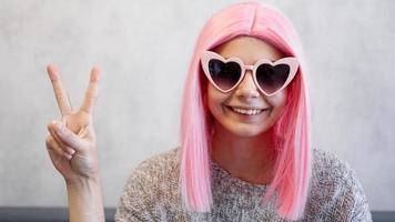 Portrait of a happy cheerful girl showing peace gesture photo