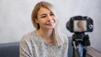 Cheerful female blogger recording video photo