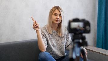 The woman shows with on a gray wall. Place for information photo