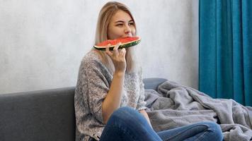 Young attractive woman eating watermelon. Woman at home photo