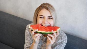 Young attractive woman eating watermelon. Woman at home photo