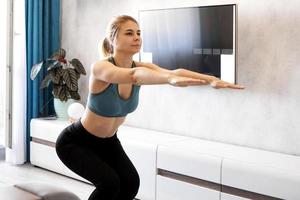Training and lifestyle concept - woman exercising and doing squats photo