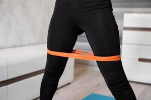 Woman during her fitness workout with rubber resistance band photo