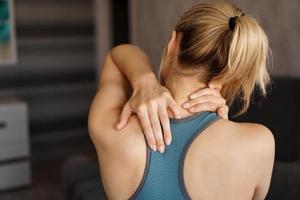 Sports injury concept. Athletic girl feeling pain in her neck photo