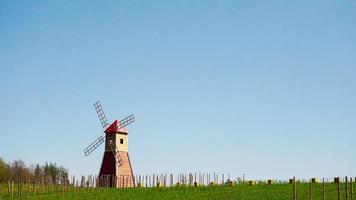 The typical red windmill standing in the fields. The rural landscape photo