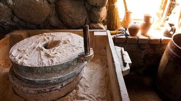 un antiguo molino de mano de piedras y madera. dispositivo de molienda de harina foto