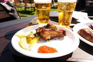 costillas de cerdo en bandeja y cerveza light. comida de la calle. comida del festival foto