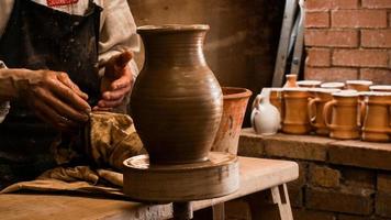 Potter hands making in clay on pottery wheel photo