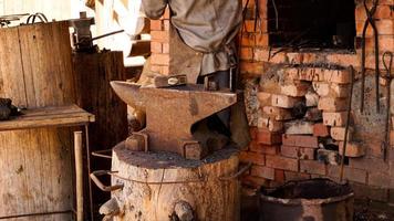 A blacksmith in an authentic workshop. Blacksmithing in the village photo