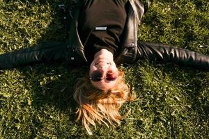 Beautiful healthy Young Woman lying and relaxing on the green grass photo